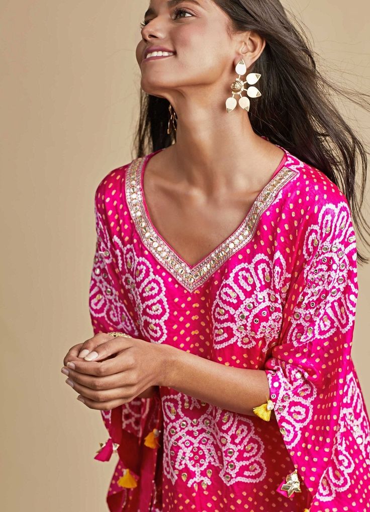 Features a peacock pattern rani pink kaftan which is highlighted with sequins and gota work and delicate tassels on sleeves. It comes with a dhoti but can be styled in various ways. Set includes an inner top to be worn below the Kaftam Composition : Kaftan -Gajji silk, Dhoti -Modal silk Care: Dry Clean Only and Vacuum Storage This product can be customised for sleeves, length of blouse and neckline Delivery : 4-6 weeks as the product is hand crafted. For more information and sizes please contact fabiliciousfashion@gmail.com or visit our Copenhagen studio.About the Designer : Pink City by Sarika, established in 2014, is a young and modern brand that offers modern indo western silhouettes with old world sophistication. With a meticulous eye for detail and an unwavering passion for creating b Bollywood Style Bandhani Print Kaftan For Festive Occasions, Pink Bollywood Kaftan With Dupatta, Bollywood Style Pink Saree Kaftan, Designer Pink Kaftan With Traditional Drape, Festive Silk Kurta With Kimono Sleeves, Festive Bandhani Print Kaftan, Traditional Bandhani Print Kaftan For Eid, Festival Kaftan With Dupatta For Diwali, Festive Kaftan With Dabka For Festivals