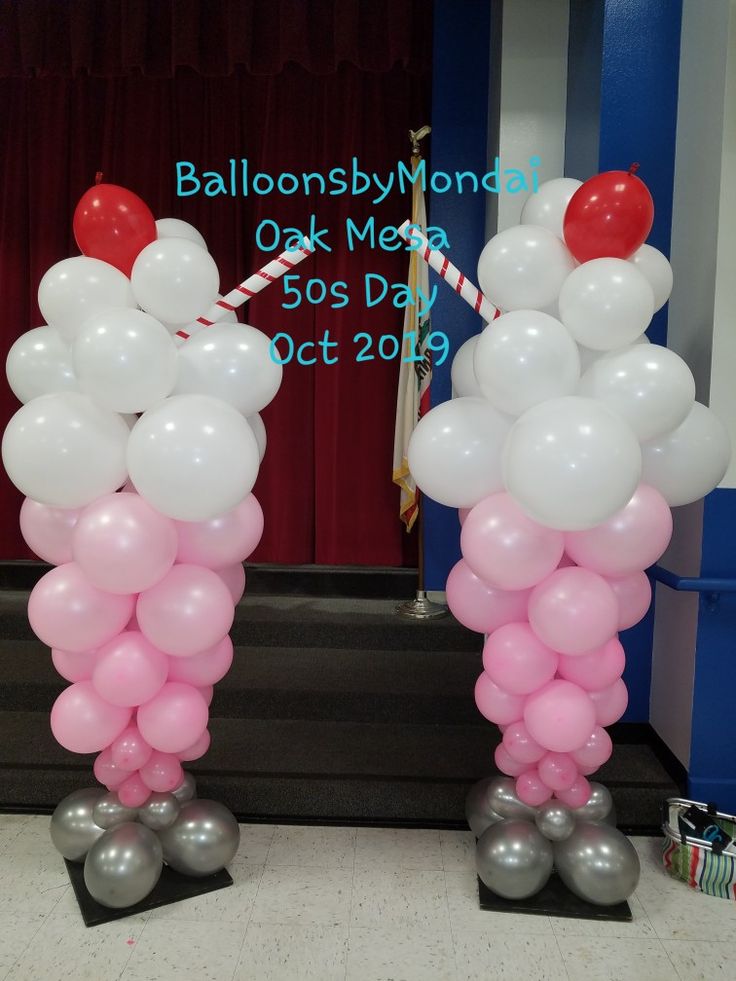 two balloons are standing in front of a stage