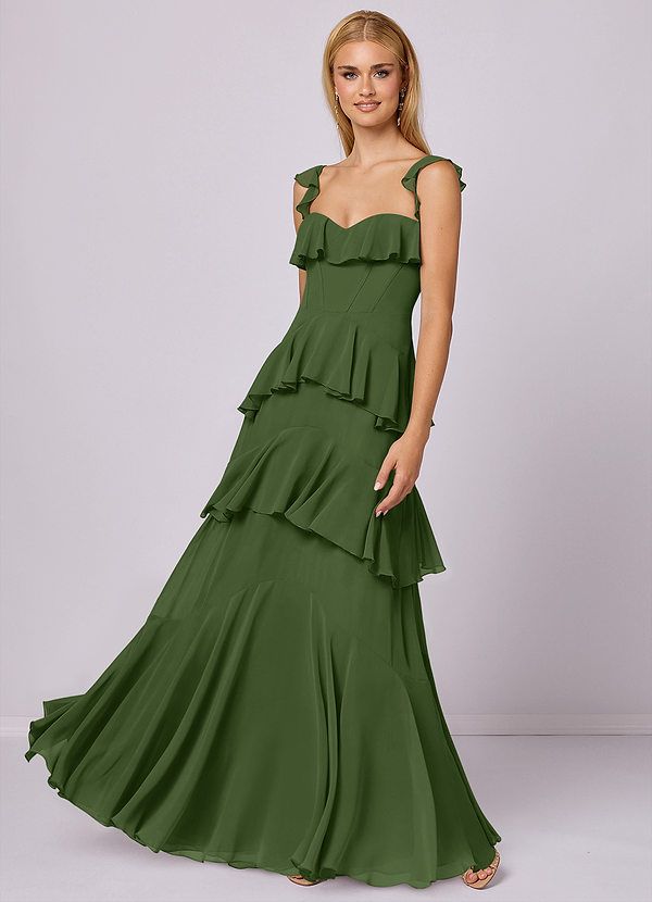 a woman wearing a green dress with tiered ruffles on the bottom and side