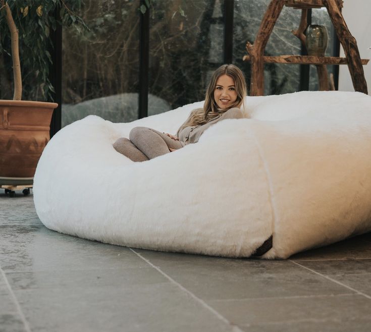 a woman is sitting on a bean bag chair