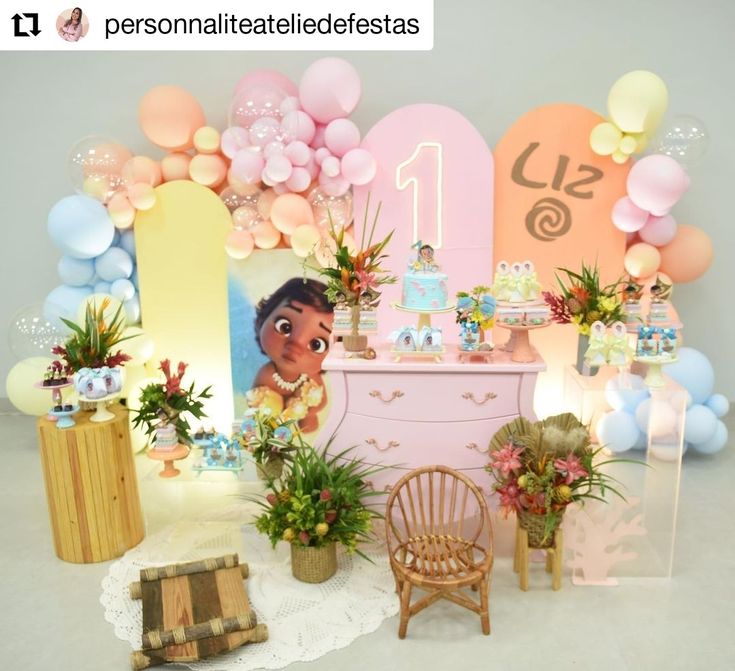 a baby's first birthday party with balloons, flowers and decorations on the wall