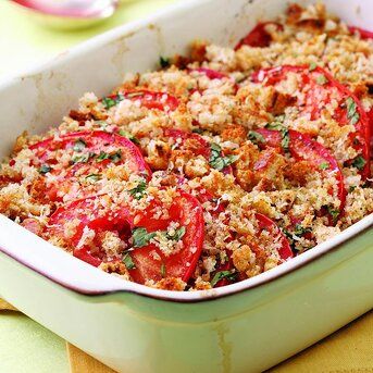 a casserole dish with tomatoes and bread crumbs