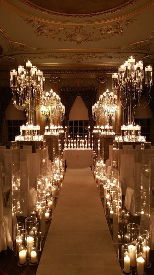 the aisle is lined with candles and chandeliers