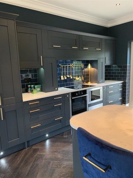 a kitchen with gray cabinets and blue counter tops is seen in this image from the front view