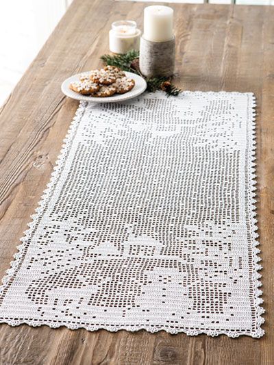 a white doily on top of a wooden table next to a candle and some cookies