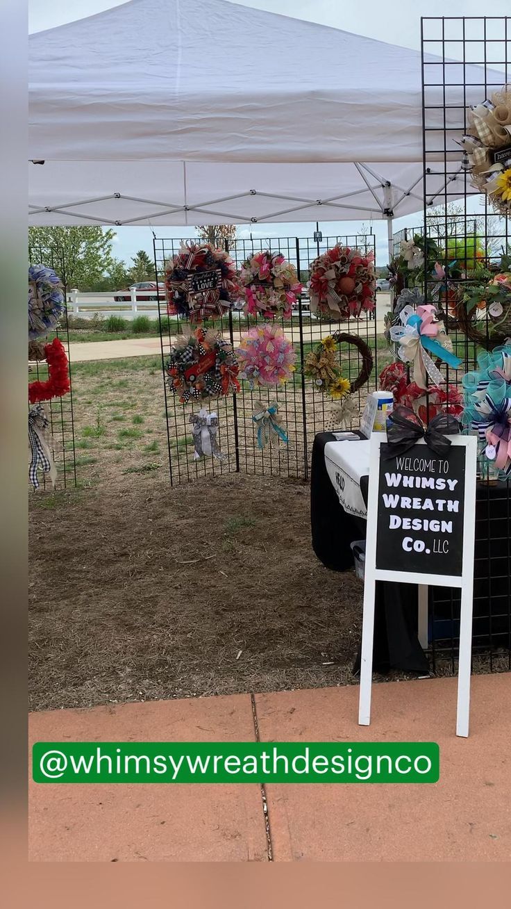 a sign that says whimsy weather design co on it next to some wreaths