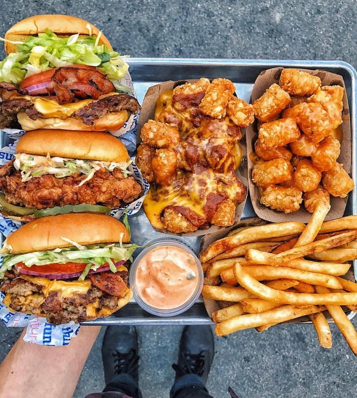 a tray filled with lots of different types of food next to fries and coleslaw