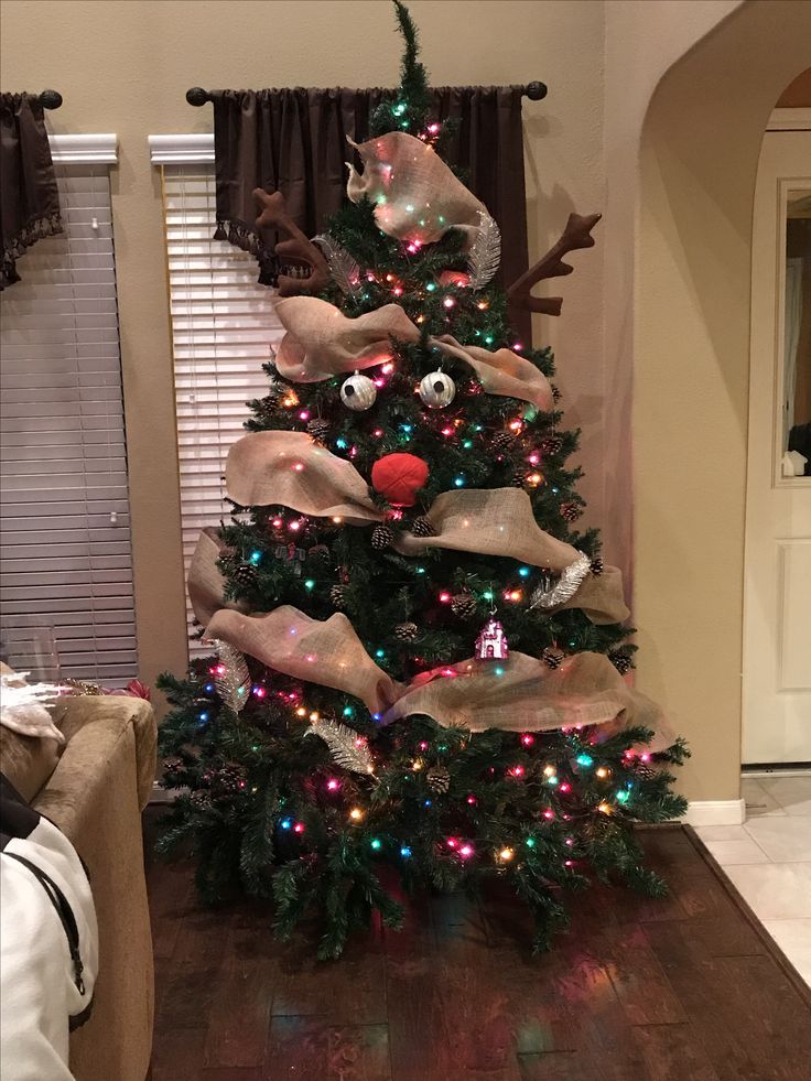 a christmas tree decorated with lights and reindeer heads