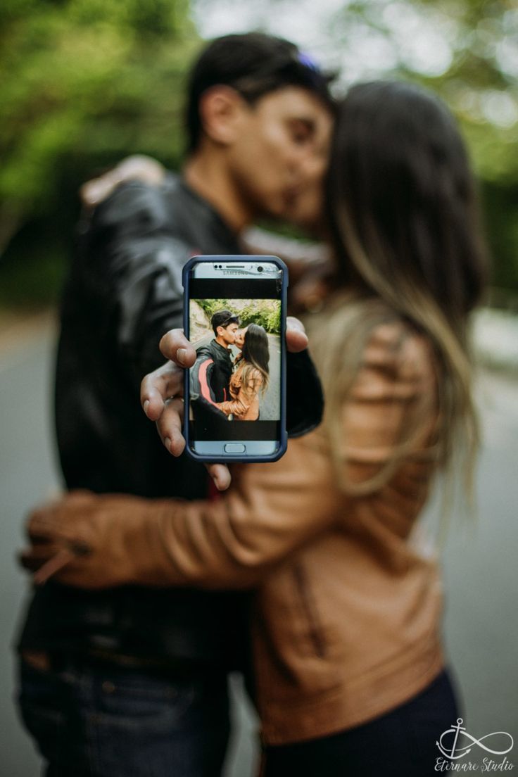 a man and woman taking a photo with their cell phone