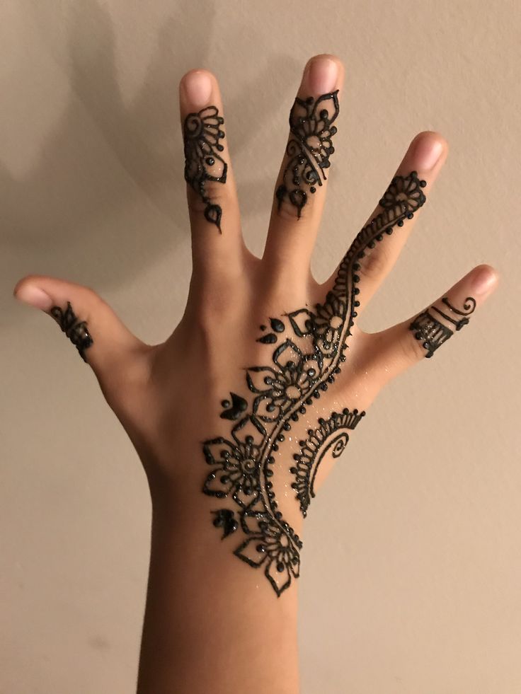 a woman's hand with henna tattoos on it