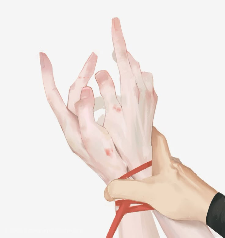 two hands are tied to each other with red string and one hand is holding something in the air