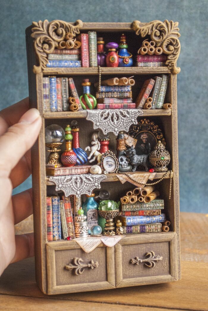 a miniature book shelf with lots of books on it's sides and shelves in the middle