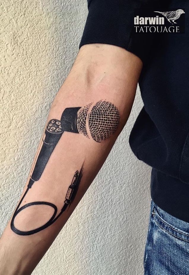 a person with a microphone tattoo on their arm