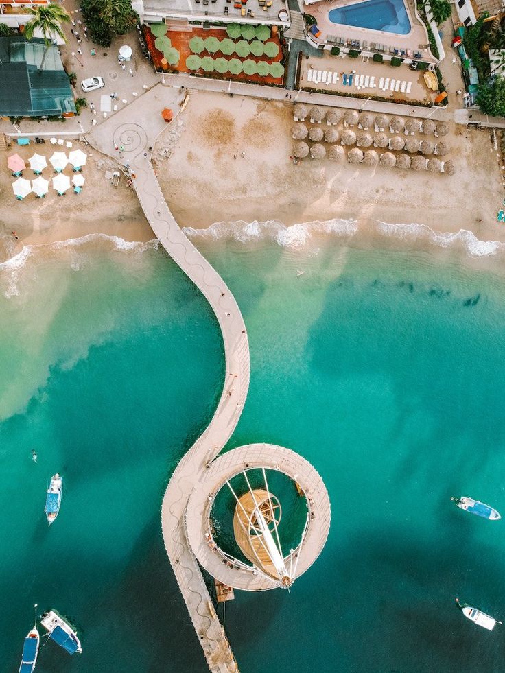 an aerial view of a pier and boats in the water