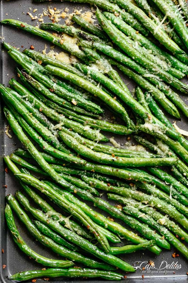 asparagus on a baking sheet with seasoning sprinkles