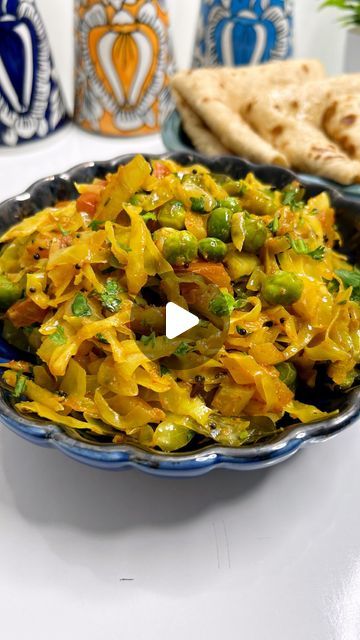 a bowl full of food sitting on top of a table next to some pita bread