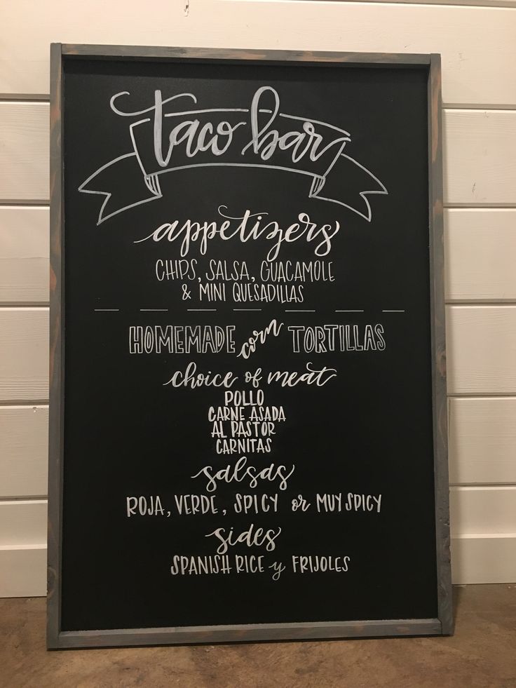 the menu for taco bar is displayed on a blackboard in front of a white wall