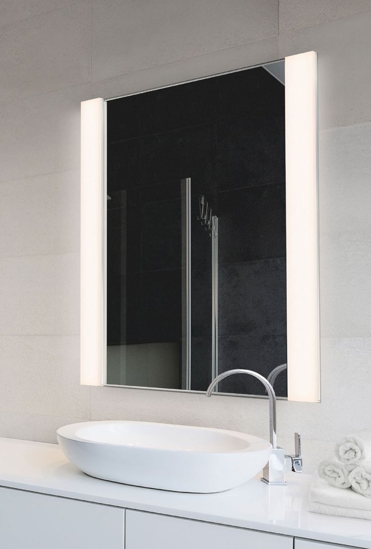 a bathroom with a sink, mirror and towel on the counter in front of it