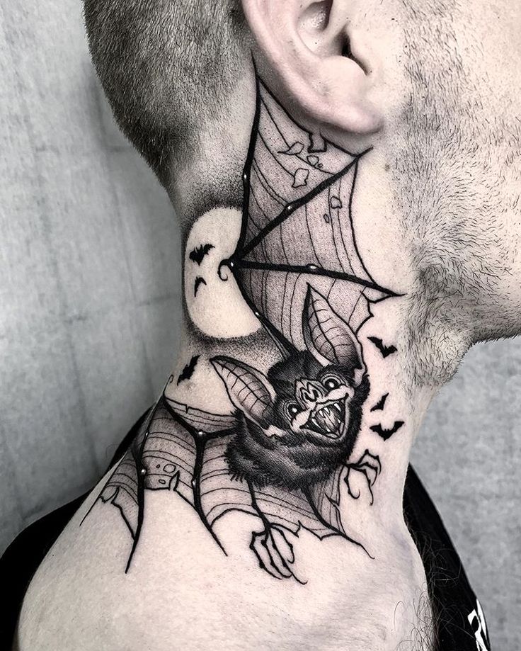 a man's neck with a spider web and bats tattoo on the back of his neck