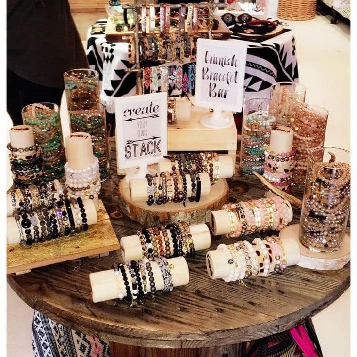 a table topped with lots of bracelets and candles