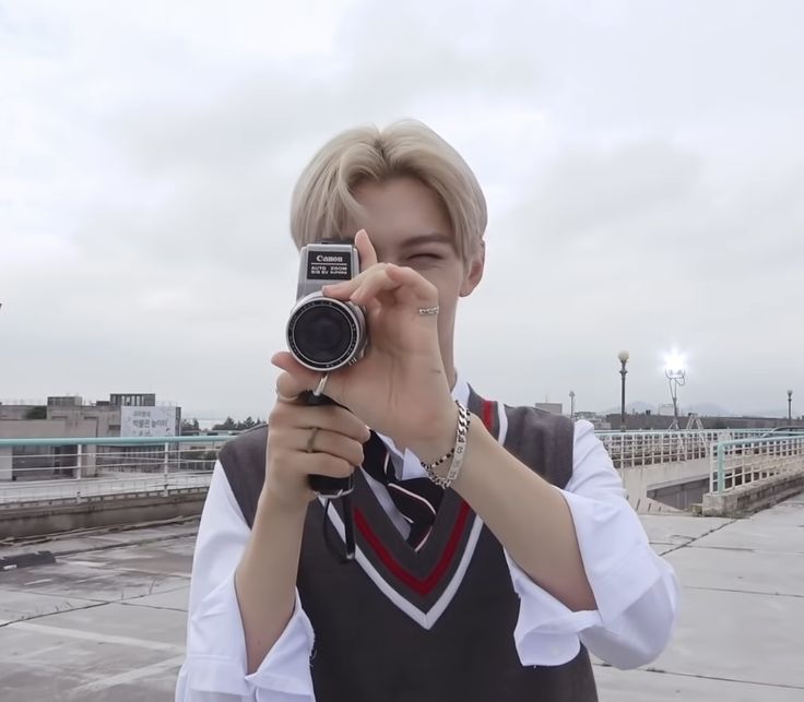 a person taking a photo with a camera in front of them on a roof top