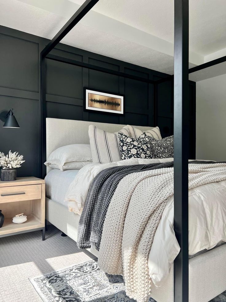 a bedroom with black walls and white bedding