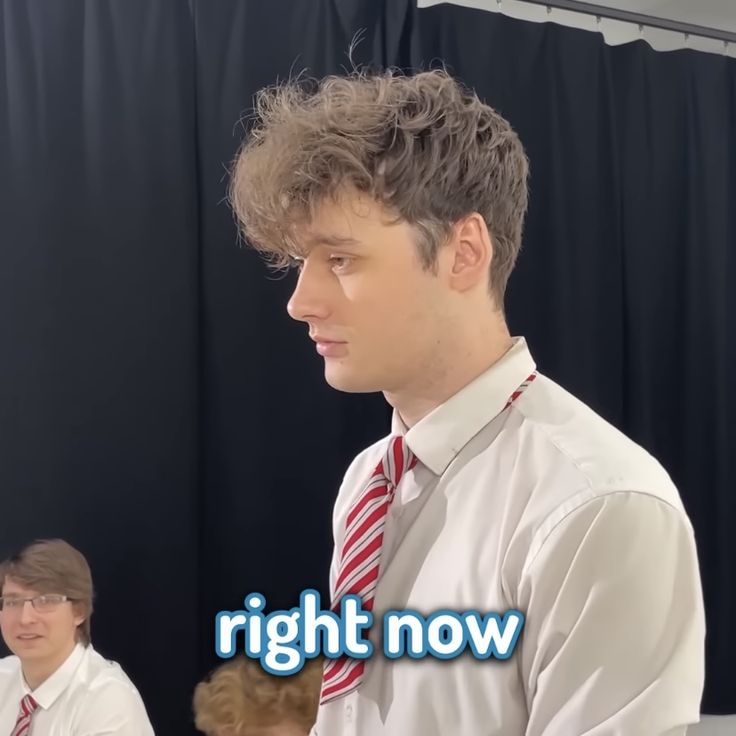 a man wearing a white shirt and red striped tie