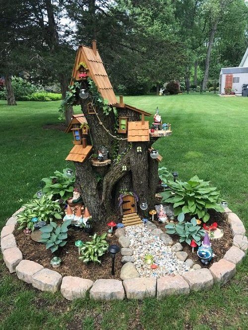 a small tree house with lots of plants and trees around it in the middle of a yard