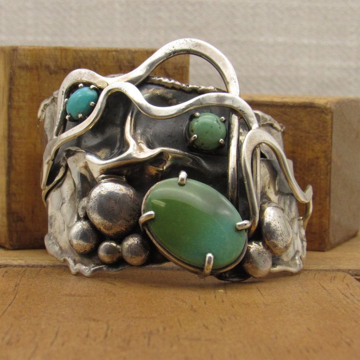 "Very unusual sterling silver and turquoise cuff bracelet. Stamped Mark Z Sterling. The front is 2 1/8\" tall. The inside measures 6 1/8\" including the 1 3/4\" opening. There are 3 stones, one large turquoise stone and two small ones prong set on this cuff. There are 7 silver balls, ribbons of silver and interesting background treatment. Good condition. One of a kind, I believe. SBT-5" Antique Turquoise Jewelry, Metal Ideas, Antique Turquoise, Square Stone, Turquoise Bracelet Cuff, Unusual Jewelry, Turquoise Cuff, Bracelet Cuff, American Jewelry