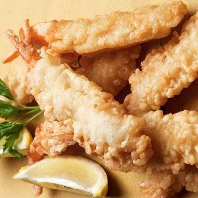 fried food with lemon wedges and garnishes on the side, ready to be eaten