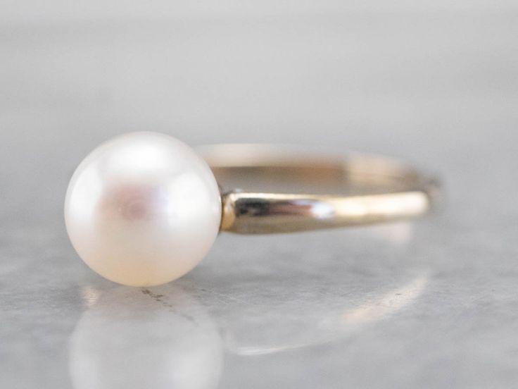 This pearl solitaire ring will be a classic for years to come! The pearl shimmers to perfection, with a glowing ghostly white hue. Crafted from 18 karat white gold, this ring is refined beauty at its very best! Metal: 18K White Gold Gem: Pearl Gem Measurements: 6.6 mm, Round Ring Size: 5 Marks: "18K" Stamped on the inside band White Pearl Drop Ring For Formal Occasions, Formal White Pearl Ring, Classic Round Pearl Ring With Pearl Drop, Classic White Gold Pearl Ring With Pearl Drop, Classic White Pearl Ring With Charm, Classic White Pearl Ring With Pearl Charm, Classic Pearl Ring With Pearl Drop, Classic White Gold Pearl Drop Ring, Classic Pearl Drop Ring