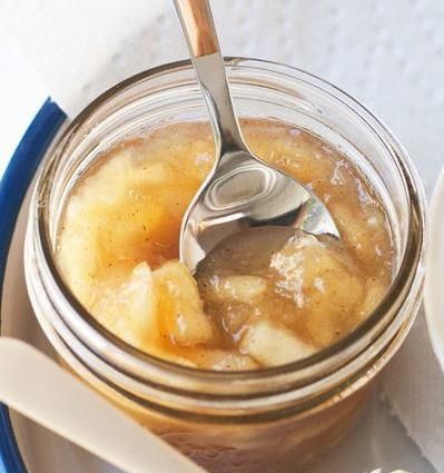 a spoon in a jar filled with food on top of a white and blue plate