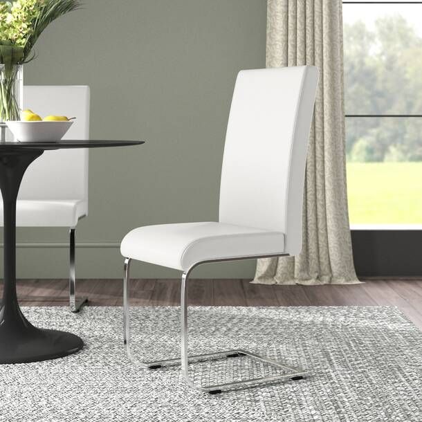 a dining room table with two chairs and a bowl of fruit on the table next to it