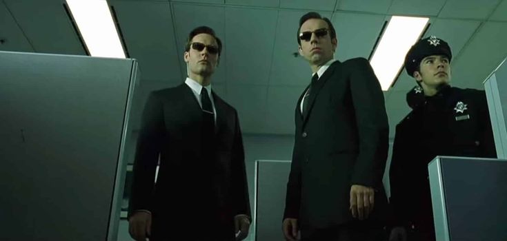 two men in suits and sunglasses standing next to each other