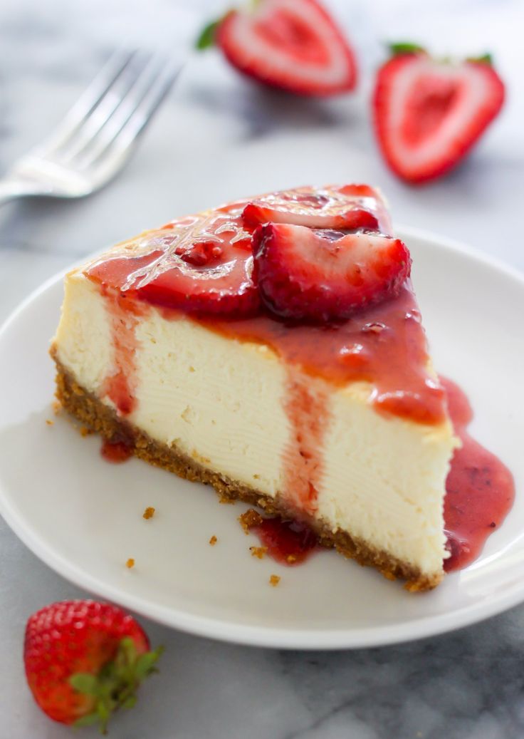 a slice of cheesecake with strawberries on the side