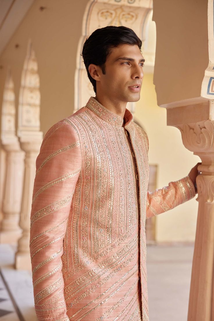 Step into elegance with our flamingo pink embroidered sherwani set, meticulously handcrafted with zardozi, french knots, and aari work. This exquisite ensemble blends traditional craftsmanship with contemporary finesse, perfect for weddings and special occasions. The vibrant flamingo pink hue adds a touch of charm and sophistication, while the intricate embroidery enhances its regal appeal. Ideal for those who appreciate meticulous detailing and timeless style, this sherwani set promises to elev Pink Sherwani For Groom, Pink Sherwani, Sherwani For Groom, Embroidered Sherwani, Sherwani Groom, Flamingo Pink, French Knots, Aari Work, Intricate Embroidery