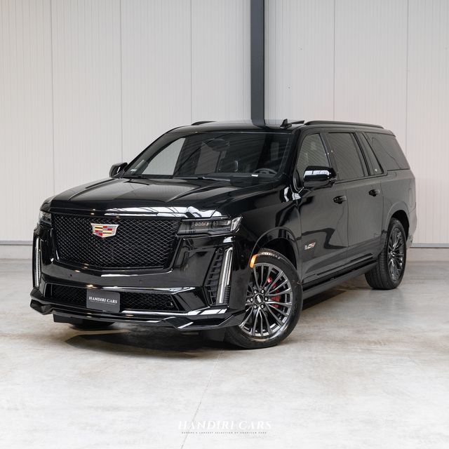 a black suv is parked in front of a white wall and some doors on it