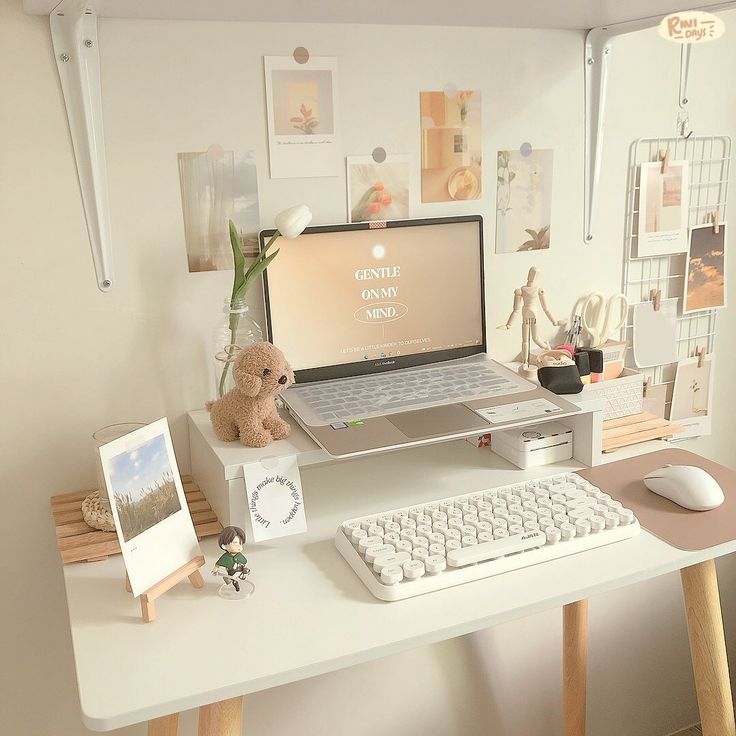 a laptop computer sitting on top of a white desk next to a keyboard and mouse