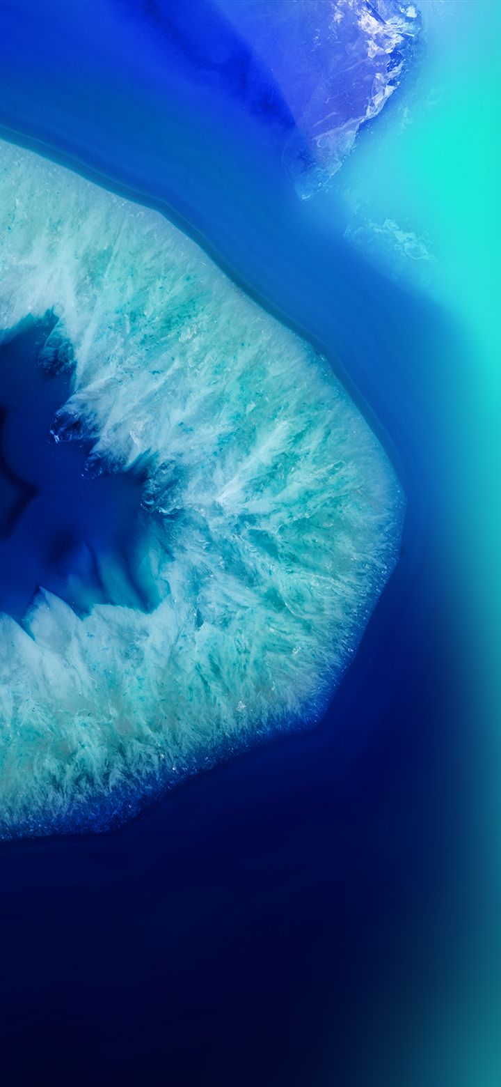 an aerial view of the ocean and landforms in blue hues, from space