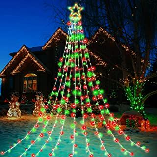 a lighted christmas tree in front of a house