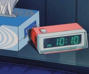 an alarm clock sitting on top of a table next to a box with the time