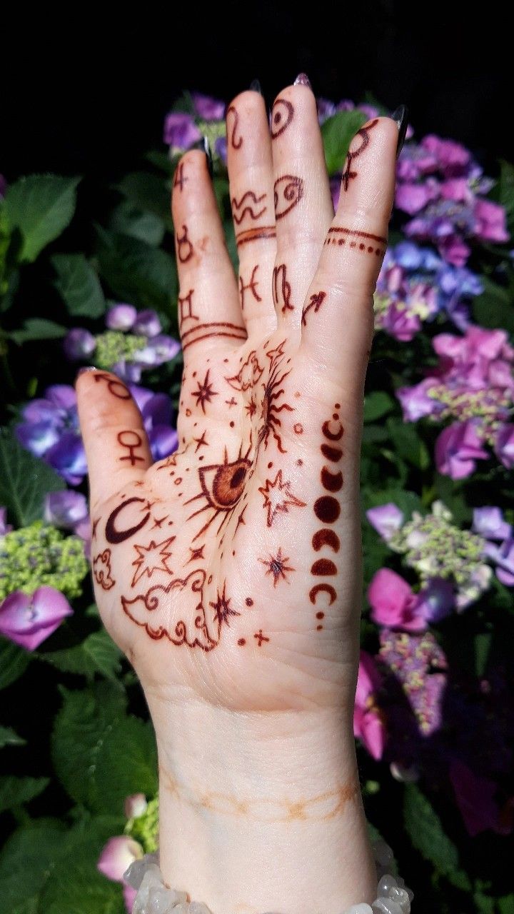 a person's hand with hendix on it and flowers in the background