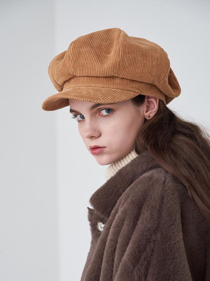 a woman wearing a brown hat and coat