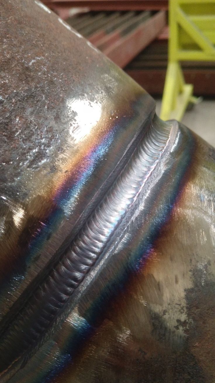 a close up view of the side of a metal object with rainbow paint on it