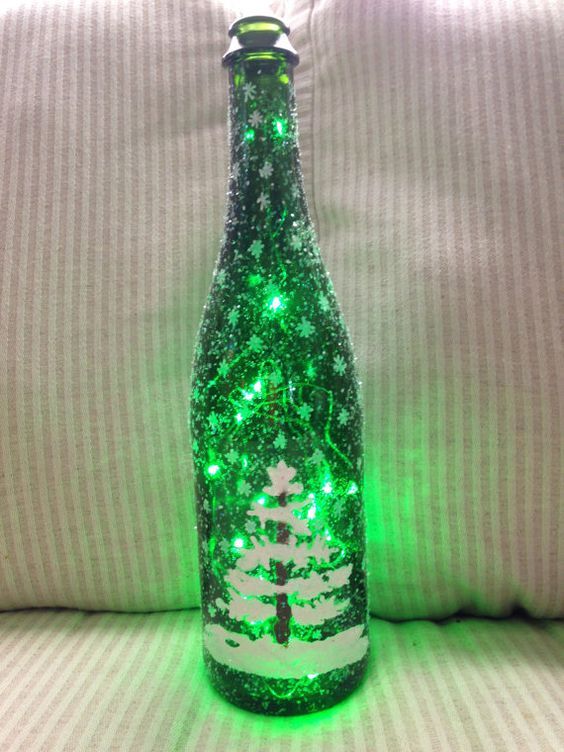 a bottle that is sitting on a couch covered in green lights and snowflakes