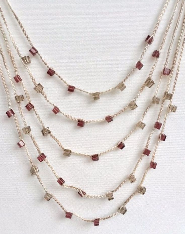 a multi stranded necklace with red and white glass beads on silver plated chain