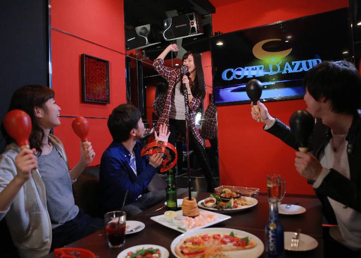 a group of people sitting around a table with food and drinks in front of them