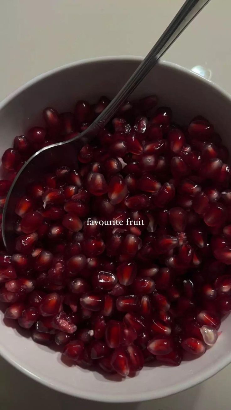 pomegranate fruit in a white bowl with a spoon