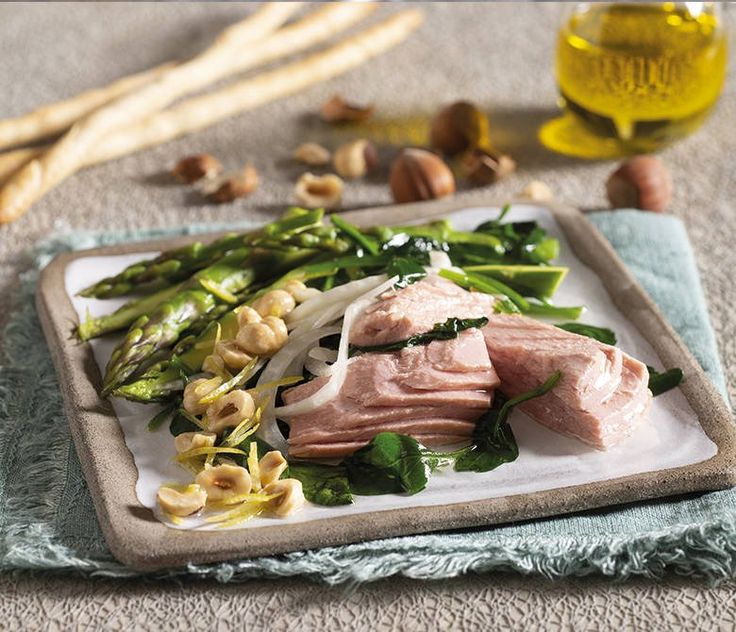 a white plate topped with meat and veggies on top of a blue towel