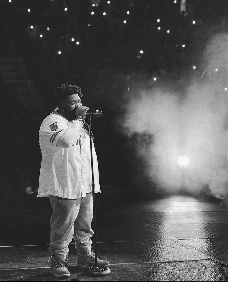 a man standing on top of a stage holding a microphone